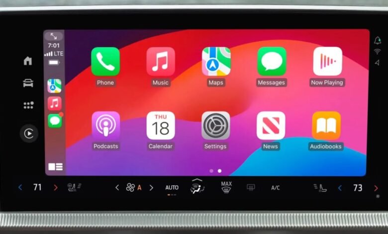 Close-up of a car's touchscreen displaying Apple CarPlay interface with app icons.