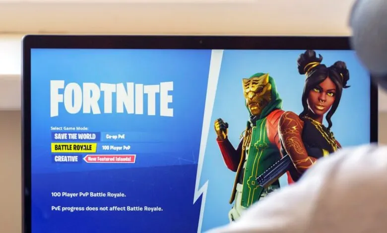 Close-up of a laptop screen displaying the Fortnite game menu with characters.