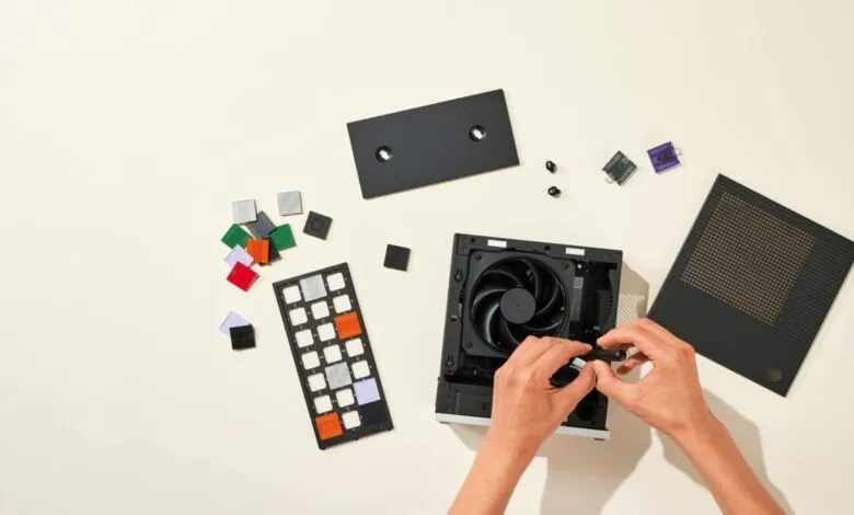 Hands assembling a black computer tower with colorful modular components.