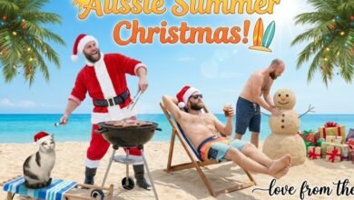 Men in Santa hats celebrating Christmas on a sunny beach with a barbecue and sand snowman.