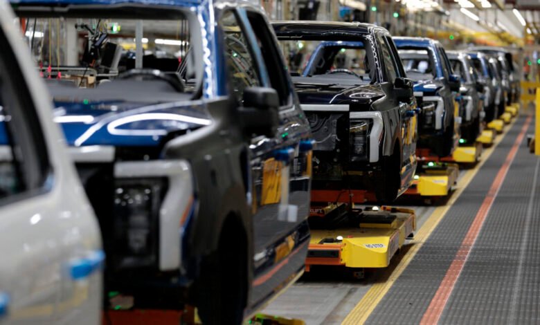 Ford F-150 Lightning electric trucks on an assembly line in a factory.