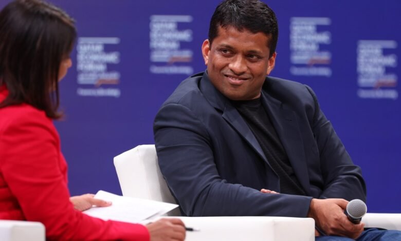 Byju Raveendran at a forum, smiling and holding a microphone.