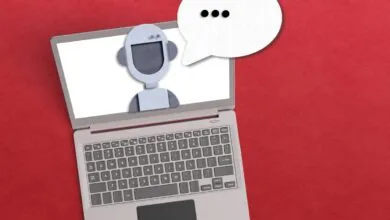 A laptop screen displays a friendly robot character with a speech bubble.