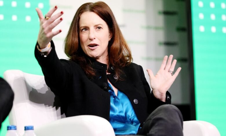 Woman with auburn hair gestures during a panel discussion.