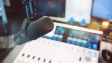 Professional microphone in a recording studio with a mixing console in the background.