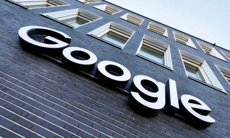 Close-up of the Google logo on a dark brick building facade.