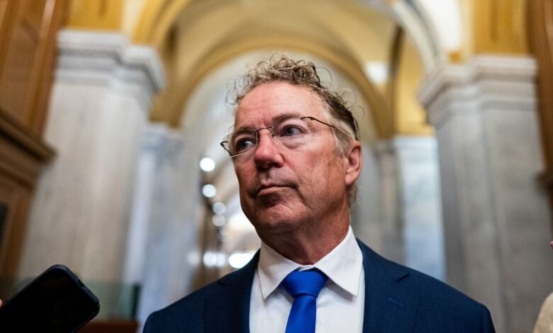 Senator Rand Paul in a suit and tie, looking off-camera with a serious expression.