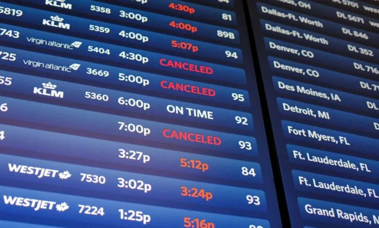 Close-up of a digital airport departure board showing flight information and statuses.