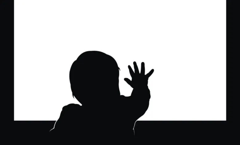 Silhouette of a toddler's head and hand reaching towards a blank white screen.