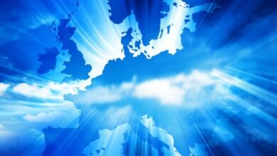 Silhouette map of Europe against a bright blue sky with radiating light beams.