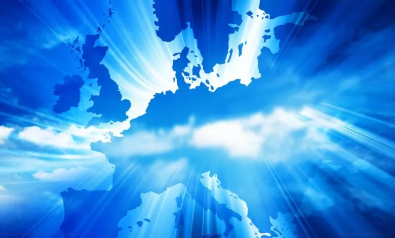 Silhouette map of Europe against a bright blue sky with radiating light beams.