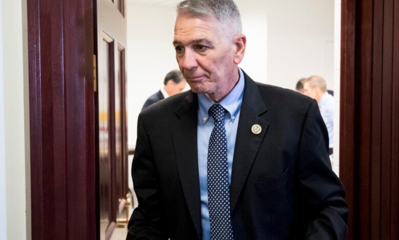 Rep. Ralph Abraham exits a room in a dark suit and patterned tie.