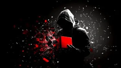 Silhouette of a hooded figure holding a red cube, with fragments exploding outwards.