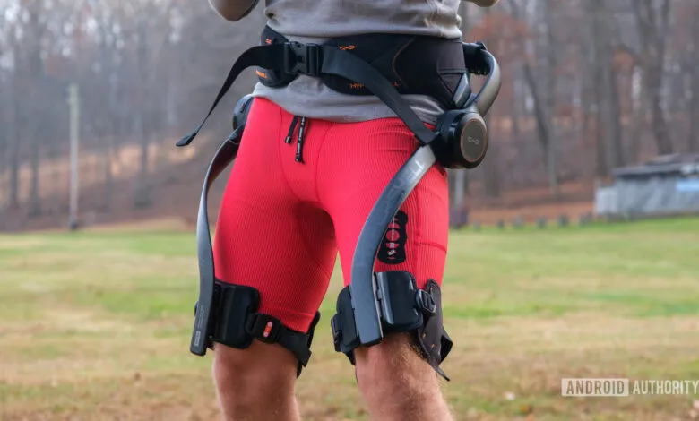 Person wearing Hypershell X exoskeleton for leg support outdoors.