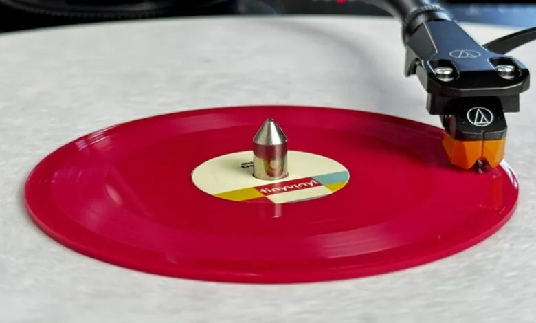 Close-up of a red vinyl record spinning on a turntable.