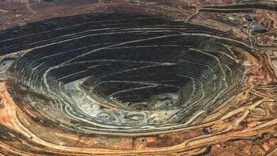 Aerial view of a massive open-pit mine with terraced layers and winding roads.