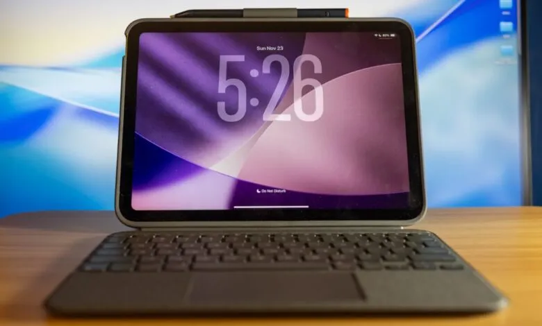 iPad with keyboard case showing time 5:26 on purple wallpaper.