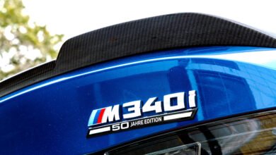 Close-up of a blue BMW M340i 50 Jahre Edition badge with a carbon fiber spoiler.