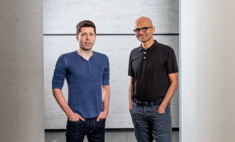 Sam Altman and Satya Nadella standing side-by-side in a modern office setting.