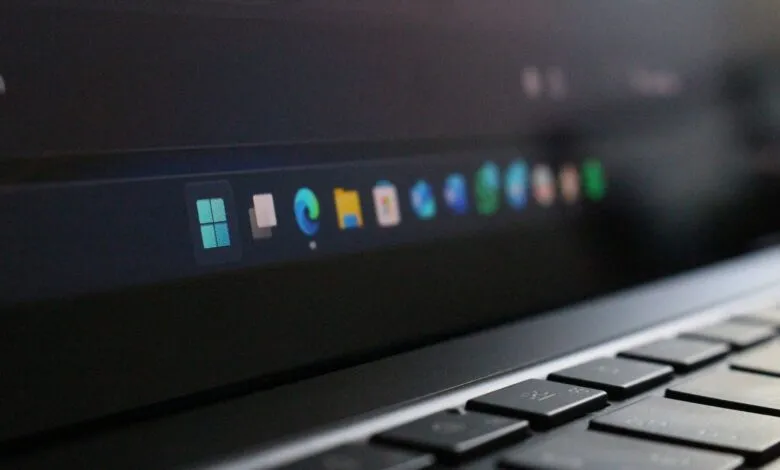 Close-up of a laptop screen showing the Windows 11 taskbar with application icons.