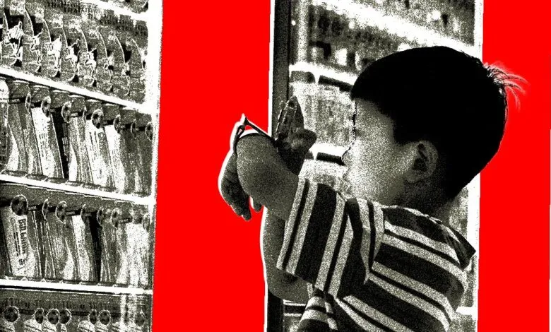 A young boy in a striped shirt looks at shelves of canned goods.