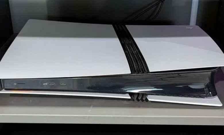 A white and black Sony PlayStation 5 console lying horizontally on a shelf.