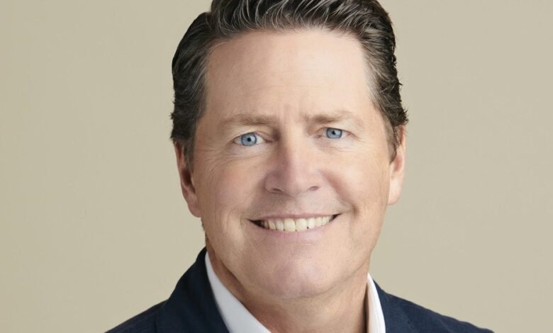 Close-up portrait of Peter Naylor smiling with bright blue eyes.