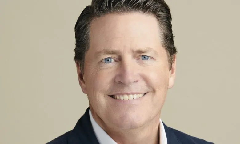 Close-up portrait of Peter Naylor smiling with bright blue eyes.