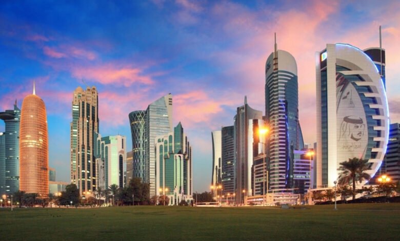 Doha skyline with modern skyscrapers and a grassy park at sunset