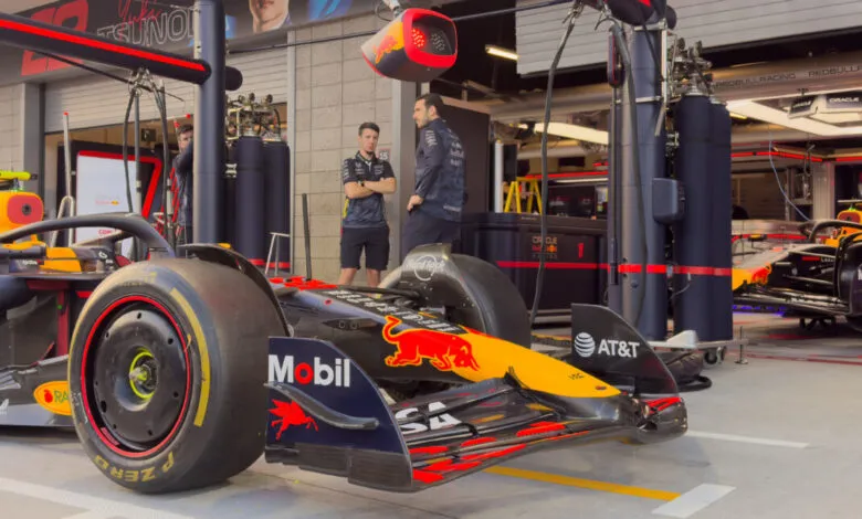 Red Bull Racing Formula 1 car in the pit lane with crew members.