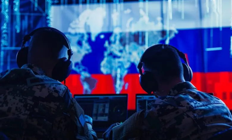 Two individuals in camouflage uniforms wearing headphones, facing screens displaying a world map and the Russian flag.