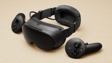 Black virtual reality headset and two controllers on a textured beige background.