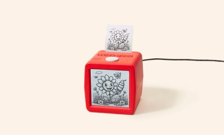 Red Stickerbox printer showing sunflower design on screen and printed sticker.