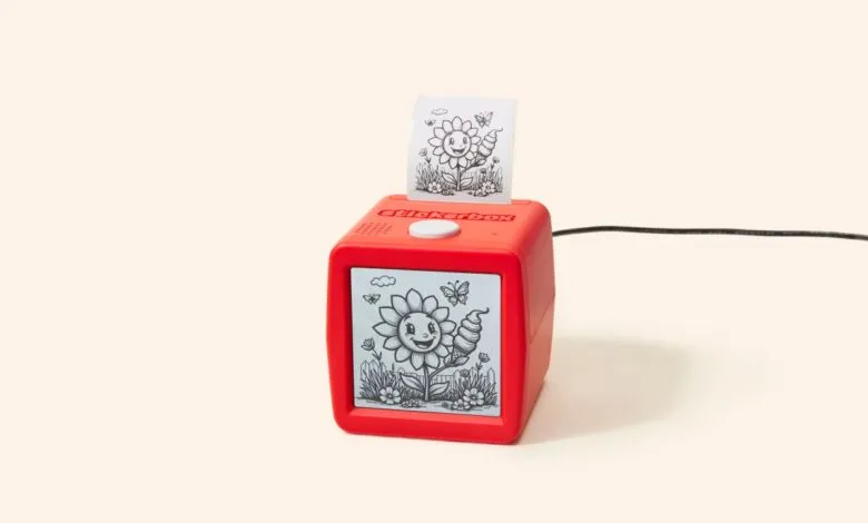 Red Stickerbox printer showing sunflower design on screen and printed sticker.