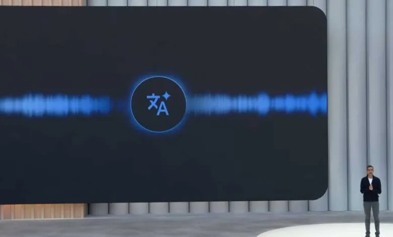 A man stands on stage presenting a screen showing the Google Translate logo and a blue waveform.