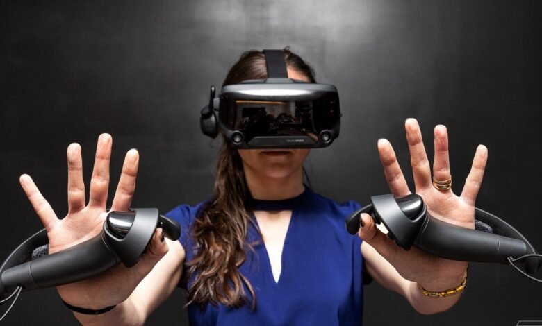 Woman wearing a VR headset and holding controllers, with hands outstretched.