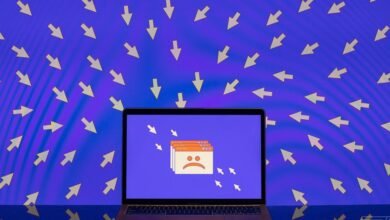 Laptop screen displays error messages with a sad face, surrounded by many mouse cursors pointing inwards.