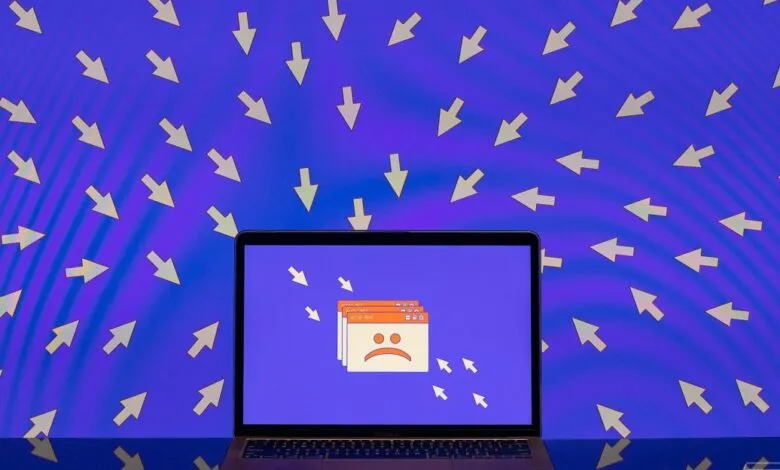 Laptop screen displays error messages with a sad face, surrounded by many mouse cursors pointing inwards.