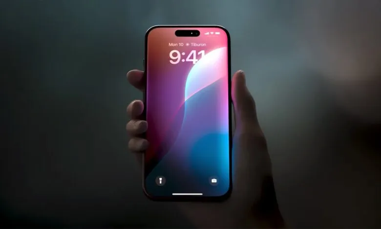 Hand holding an iPhone displaying a colorful abstract wallpaper and the time 9:41.