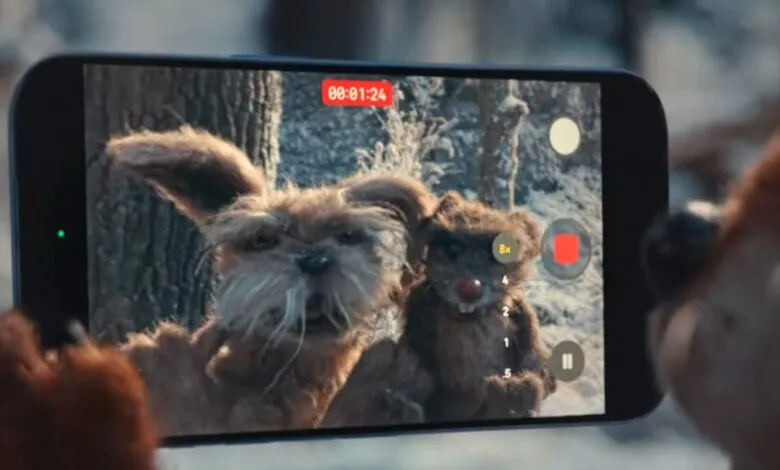 iPhone screen shows two furry creatures in a snowy forest, being filmed.