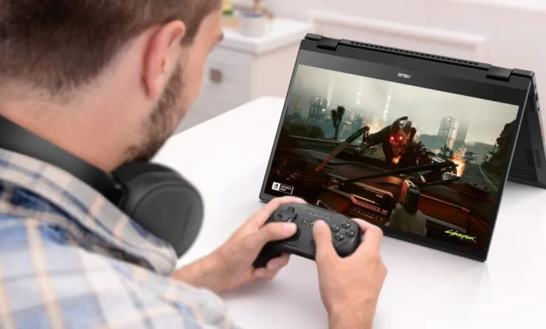 Man playing Cyberpunk 2077 on an Asus Chromebook with a controller and headphones.