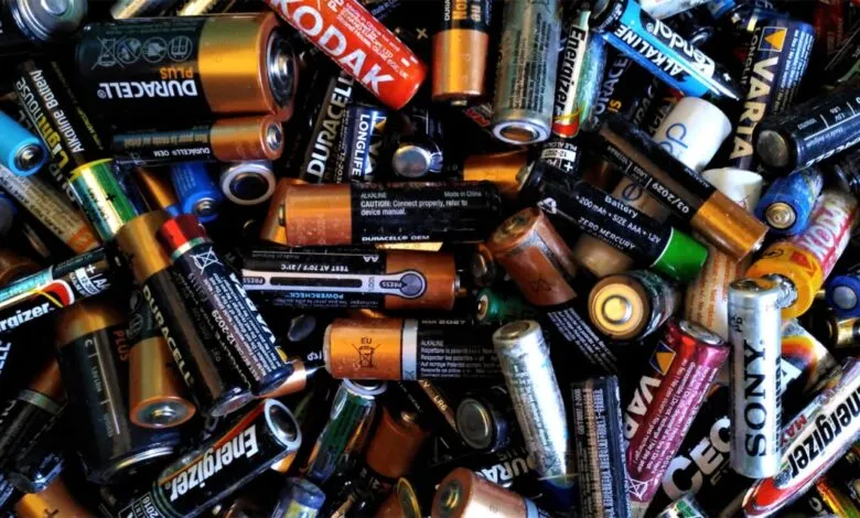 A large pile of various used and new batteries, including AA, AAA, and C sizes.