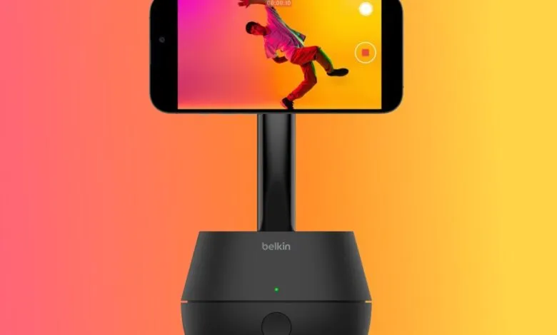 Black Belkin phone mount with a smartphone displaying a dancer against a colorful background.