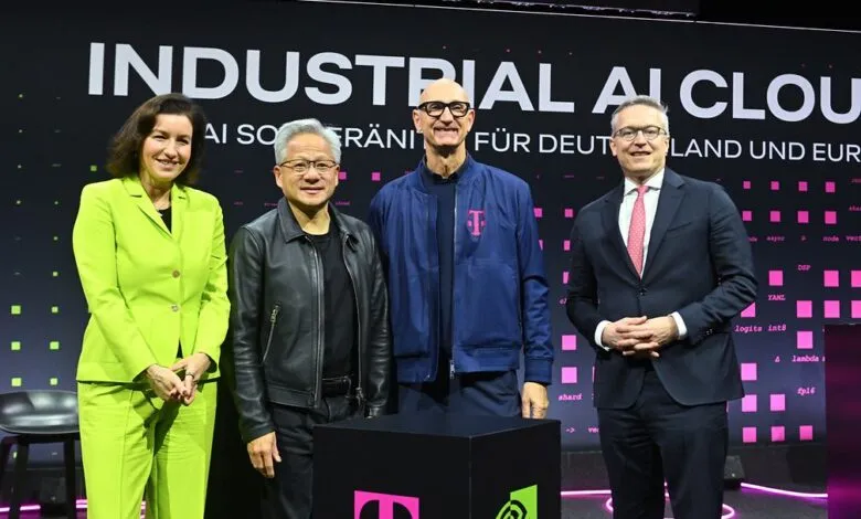 Four individuals stand on a stage in front of a screen displaying 'INDUSTRIAL AI CLOUD'.