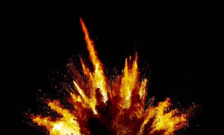 A vibrant explosion of orange and yellow flames against a stark black background.