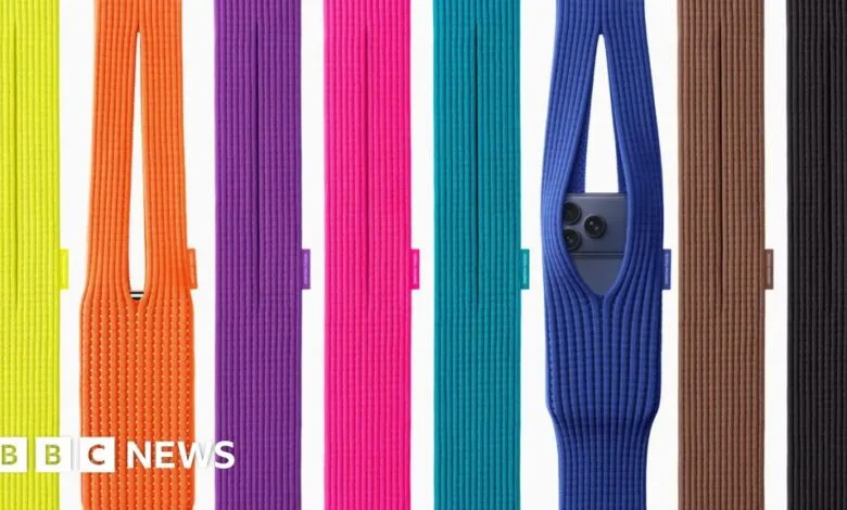 A collection of colorful knitted phone sleeves, one holding a smartphone.