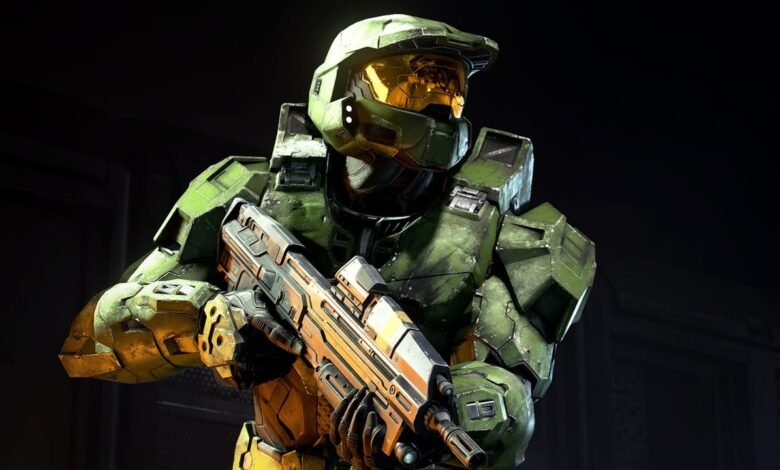 Master Chief in green armor holding a futuristic rifle, looking to the side.