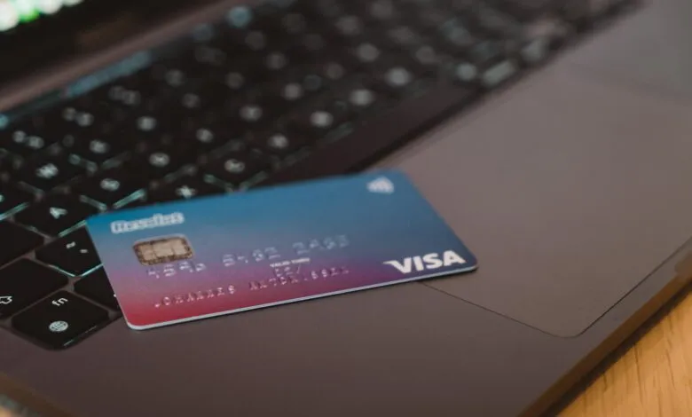 A credit card with Visa and Revolut logos rests on a laptop keyboard.