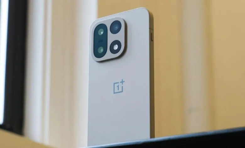 Close-up of the rear camera module and logo on a silver OnePlus smartphone.