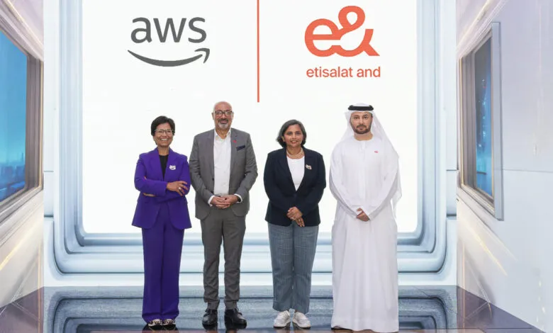 Four individuals stand in front of AWS and Etisalat logos.